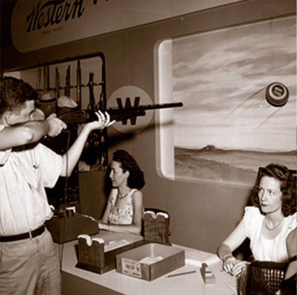 Vintage photograph of a man pretending to aim at a picture of a target